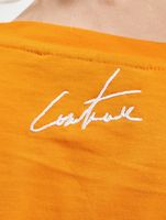 Le haut court Couture Club avec un imprimé gothique superposé en orange