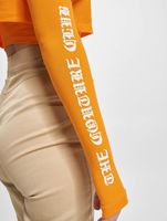 Le haut court Couture Club avec un imprimé gothique superposé en orange