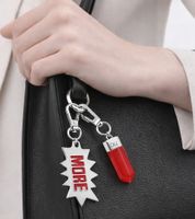 Stylisches Calvin Klein Charm-Set Downtown Edelstahl-Anhänger mit kontrastfarbigen Harz und MORE-Schriftzug Taschen-Accessoires 7x1,3cm KJJCRA090100 Silber/Rot