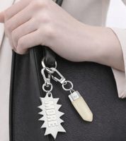 Ensemble de breloques Calvin Klein Downtown : Pendentifs en acier inoxydable avec résine contrastante et logo « MORE » - Accessoires de sac - 7 x 1,3 cm - Argent/Blanc ou Argent/Rouge